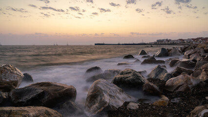 red sunset in the surf on the rocks and splashes