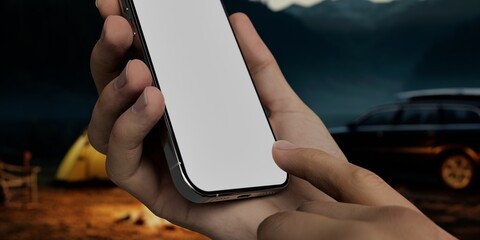 Black African-American middle aged male using smartphone with a blank white screen. Twilight, camping, camp apps mockup. Vertical phone orientation