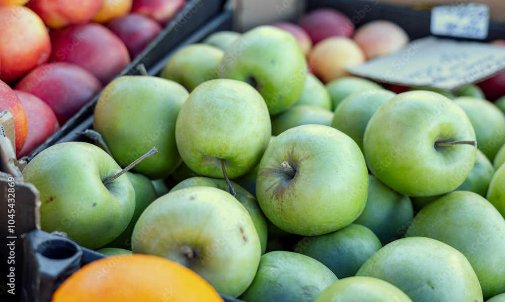 Sticker Stand of Red and green apples on the market counter. Apple on the grocery shelf. Supermarket. Apple harvest on the supermarket counter. Farm apples in boxes on a market display.