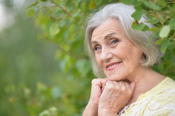 Portrait of a beautiful elderly woman in the park