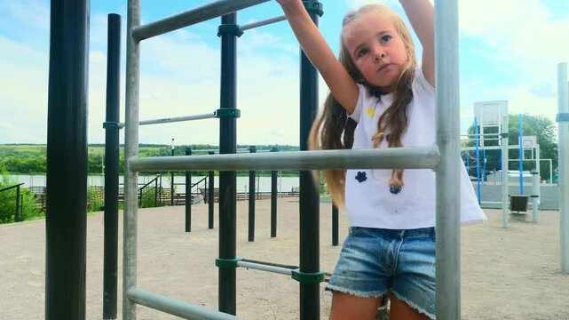 Sporty child girl doing morning workout on street sports ground. Fitness workout. a healthy family. street sports ground in a city park in casual clothes. Street workout