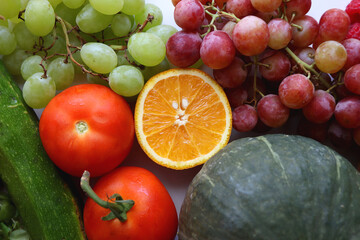 Various seasonal fruits and vegetables on white background. Summer and fall produce. Top view.