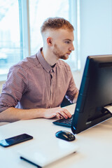 Concentrated man surfing computer at workspace