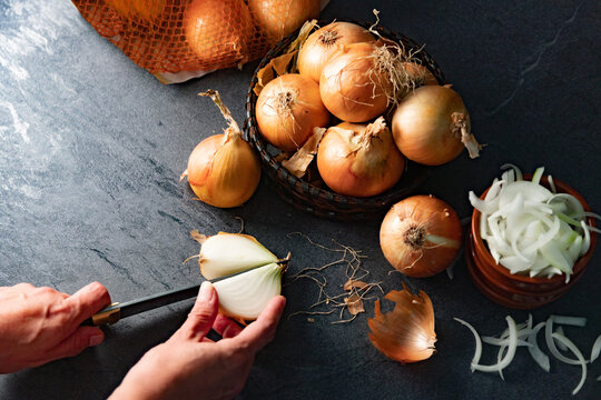 Concepto de preparaci&oacute;n de una comida. Un bol de cebollas y un bol de cebollas picadas se encuentran sobre una encimera. Las cebollas se encuentran en distintas etapas de picado.