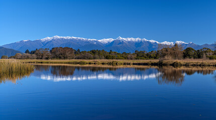 A stunning view of the snow-capped Mount , reflecting on the calm waters with a blue sky and clouds above. The majestic mountain stands tall against the backdrop of serene landscapes.