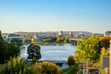 Fototapeta premium Looking across the Ottawa River from the locks of Rideau Canal at the base of Parliment Hill to Quebec and the City of Gatineau on a sunny fall day room for text