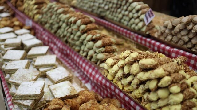 A colorful assortment of traditional pastries displayed on a checkered tablecloth. From flaky layers to nut-covered treats, each delicacy offers a unique texture and flavor.