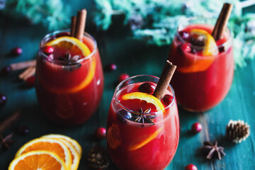 Three Glasses of Christmas Mulled Red Wine with Orange Slices Cinnamon Bark Star of Anise and Fir Tree Branches