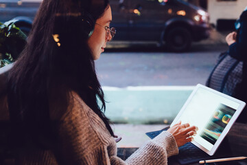 Freelance female using tablet in cafe with street view