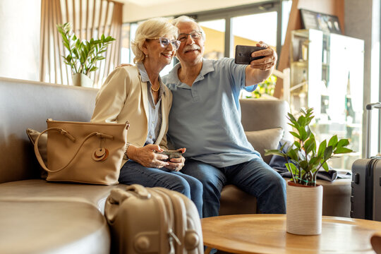 Couple of pensioners taking selfie at lobby in hotel