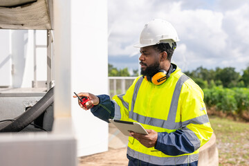 man in a yellow safety vest is working on a piece of equipment