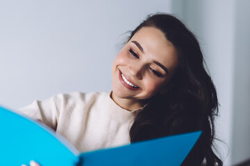 Cheerful beautiful young woman working with notebook at home