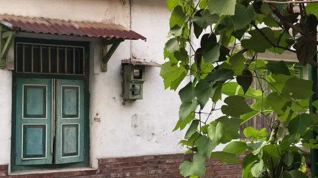 An antique wooden window of an old house in a small alley in Yogyakarta. Kota Gede, Javanese