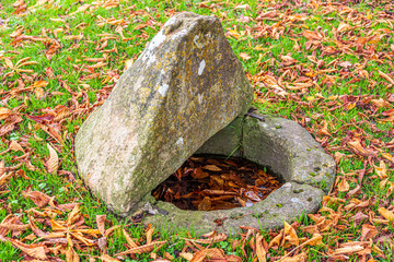 A curious old well on the green in the Cotswold village of Shilton, near Burford, Oxfordshire, England UK
