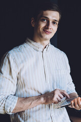 Smiling man in shirt surfing tablet