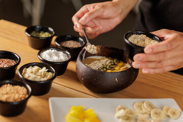 Waitress prepares a healthy breakfast with pitaya or dragon fruit smoothie, natural yogurt, seeds and cereals, apple and banana. Concept of healthy life, health.