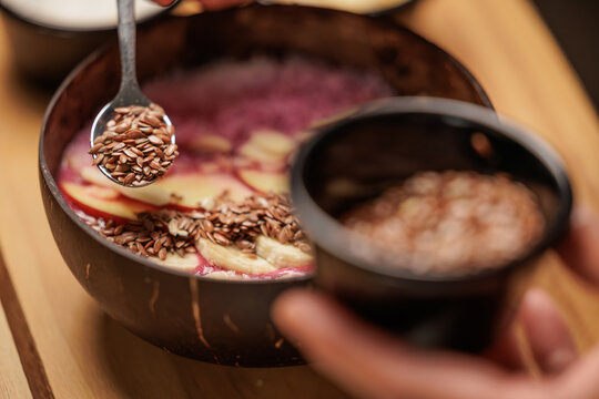Waitress prepares a healthy breakfast with pitaya or dragon fruit smoothie, natural yogurt, seeds and cereals, apple and banana. Concept of healthy life, health.