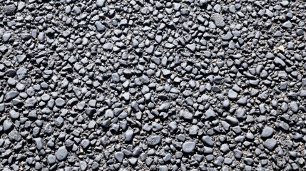 Exploring the intricate textures of smooth black asphalt adorned with scattered stones in an industrial landscape