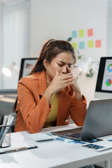 Young manager woman feeling eye strain taking off eyeglasses after long computer work at office