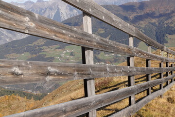 a wooden fence on a path in the mountains