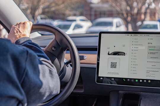 Salt Lake City, UT, US-March 19, 2024: Driver and interior of a Tesla electric vehicle with large computer display.