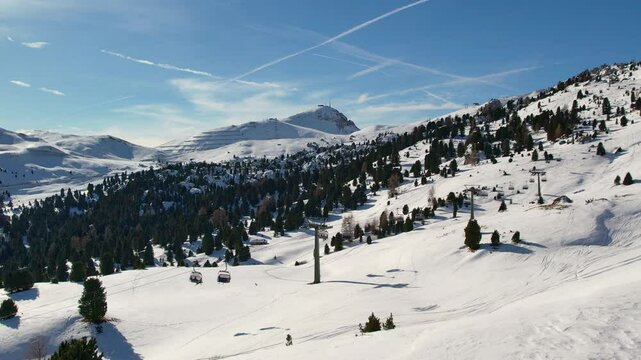 Aerial footage of Dolomiti Superski ski resort with chair lifts and snowy mountains in the Dolomites