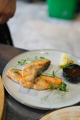 Chef Garnishing Grilled Fish with Herbs
