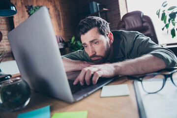 Photo of handsome young guy tired sleepy freelancer dressed green shirt comfortable startup office loft room interior