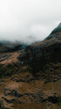 The foggy rugged Scottish Highlands of Glencoe with mountains, roads and Lagangarbh Hut in Scotland