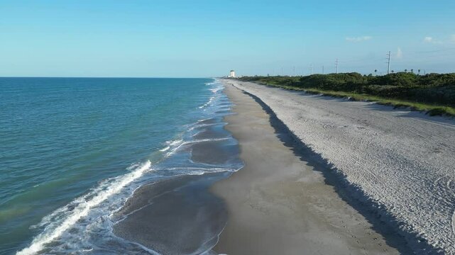 Aerial view of Floridana beach with calm waves and green spaces behind the coastline in Florida, USA