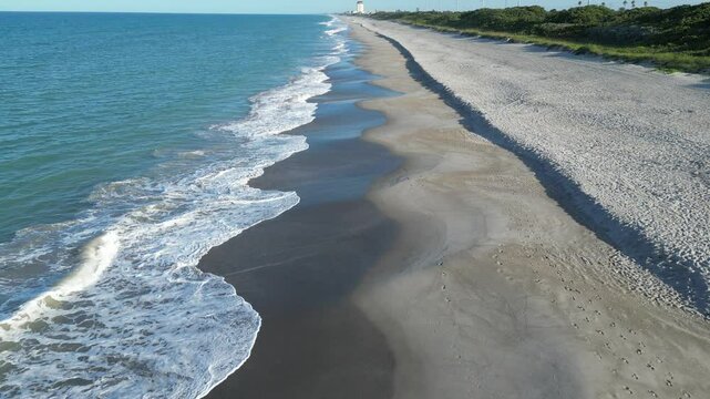 Floridana beach with calm waves and green spaces behind the coastline in Brevard, Florida, USA