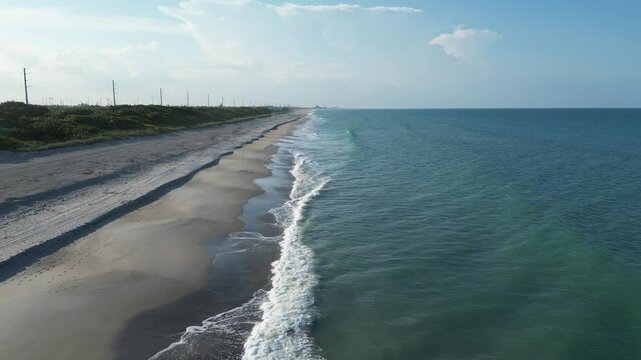 Floridana beach with calm waves and green spaces behind the coastline in Brevard, Florida, USA