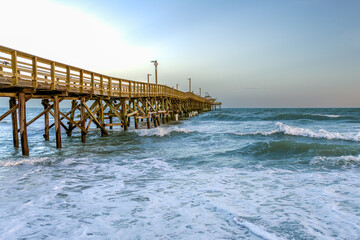 Wooden Pier Extending into the Ocean at Sunrise