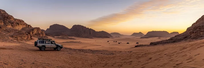 Selbstklebende Fototapeten Safari and travel to Africa, extreme adventures or science expedition in a raw desert. Sahara desert at sunrise, mountain landscape with dust on skyline, hills and traces of the off-road car  © blinkstud.io