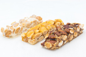 Different types of turrón (nougat), a traditional Christmas sweet in Spain, isolated on a white surface.