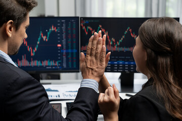 Successful in two business traders making hands high five with fist up to earn highest profit stock...