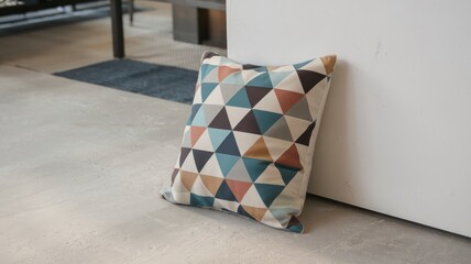 Colorful Geometric Patterned Pillow Resting Against a Wall in a Stylish Modern Interior Space