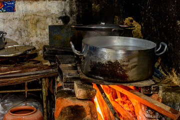 Rustic wood stove preparing food inside the kitchen of a poor house in Brazil