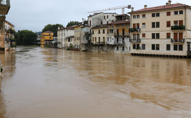 homes along the riverbank are at risk of flooding after torrential rains caused by global warming...