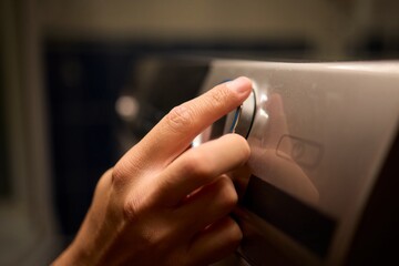 Hands Skillfully Adjusting the Washer Control in a Modern Domestic Laundry Room Environment