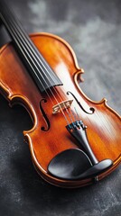 Fototapeta premium Close-up of a wooden violin on a textured surface.