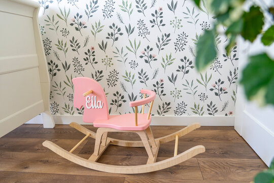 Fototapeta hobbyhorse in a nursery baby room with wallpaper