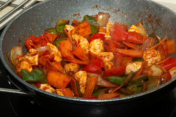 Sartén con un guiso de pollo con verduras.