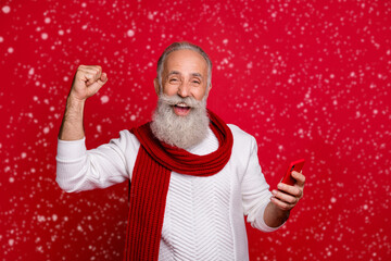 Portrait of his he nice attractive cheerful glad satisfied gray-haired man holding in hands cell fast connection speed blog like smm post isolated over bright vivid shine red background