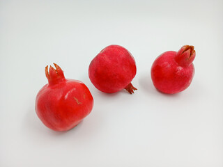 A ruby garnet. Juicy fruit for a vitamin cocktail. A whole red product. Can be used for culinary theme, postcard, supermarket. An isolated object on a white background.