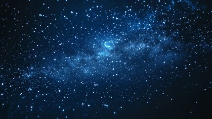 Obraz premium A stunning night sky with the Milky Way galaxy visible in the distance, a blanket of stars across a dark blue canvas.