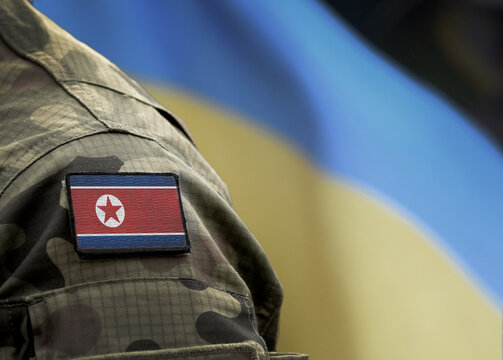Flag of North Korea on military uniform and flag of the Ukraine at background. North Korea VS Ukraine.