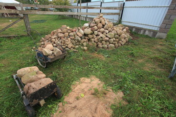 a large pile of different stones against the backdrop of a house