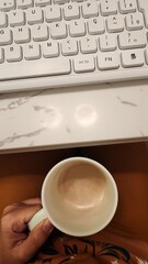 coffee cup and white computer keyboard in working time