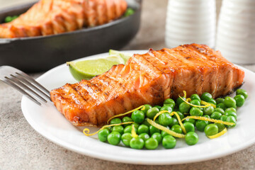 Delicious grilled salmon fillet served on grey textured table, closeup